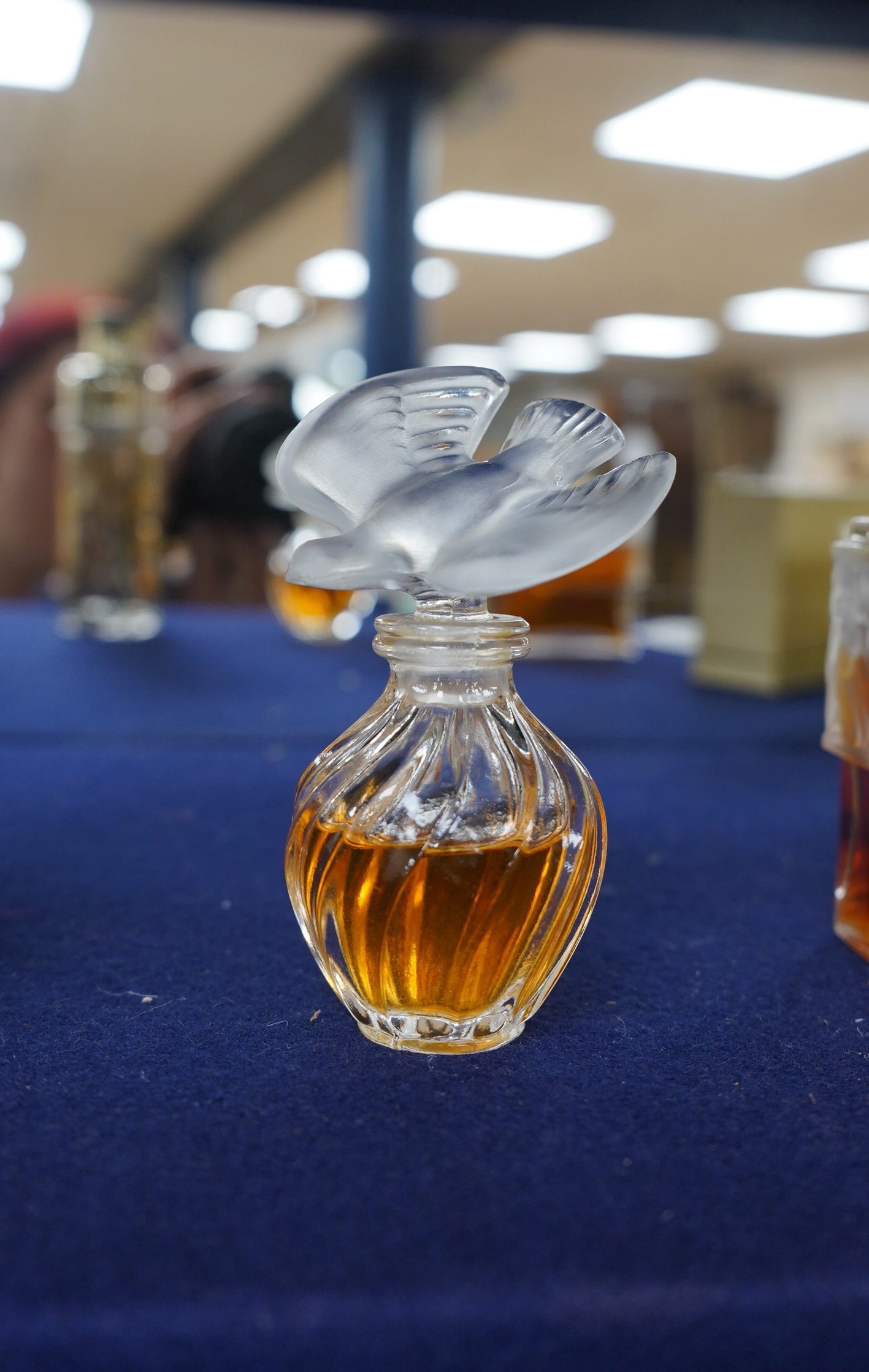 Three Lalique perfume bottles and atomisers, together with two others, tallest 14cm. Condition - fair.